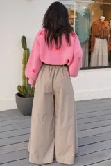 Pantalón de corte amplio y fluido, confeccionado en una mezcla de algodón y tencel. Presenta un diseño de tiro alto con pinzas frontales que aportan volumen y movimiento, además de bolsillos laterales funcionales.