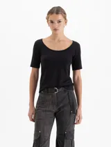 Remera negra de poliamida con elastano, de calce ajustado, con escote redondo amplio y mangas cortas al codo.