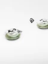 Aros tipo argolla irregulares, mitad superior en resina verde jaspeada y mitad inferior en metal plateado.