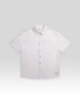 Camisa de manga corta color blanco con textura tipo waffle, cuello clásico, cierre frontal con botones de madera, bolsillo de parche en el pecho y parche con logo en el ruedo.