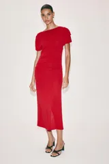 Vestido midi rojo confeccionado en punto, de cuello barco y manga corta, con detalles drapeados en los laterales.