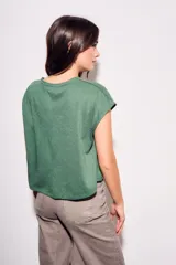 Remera gris de algodón con poliéster, corte crop, mangas cortas y bolsillo en el pecho.