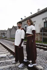 Pantalón sastrero de corte holgado y tiro alto, color marrón chocolate, con cintura elástica y lazo ajustable del mismo tono.