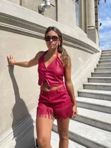 Top rojo de cuero sintético con cuello halter y cierre frontal con lazos.