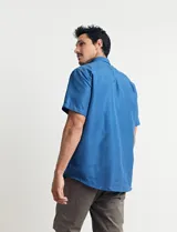 Camisa azul con estampado de lunares blancos, de manga corta y corte clásico.