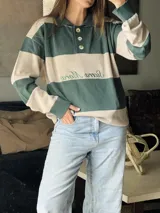 Sweater de punto con cuello polo y botones, a rayas horizontales color marrón y beige.