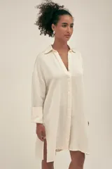 Camisola corta color crema confeccionada en lino-tencel con botones nacarados y bolsillos laterales.