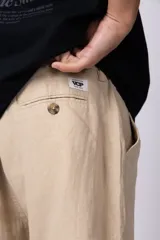 Bermuda de lino color beige, de corte recto y diseño relajado, con cintura elástica y bolsillos laterales.