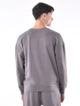 Buzo negro de corte holgado, con cuello redondo y mangas largas.