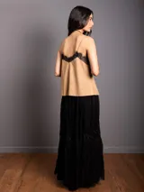 Top de breteles finos estilo camisola, confeccionado en material símil gamuza color negro, con detalle de encaje en el escote y costura vertical frontal.