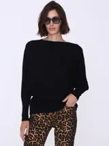 Sweater negro de punto con cuello redondo y mangas largas de corte murciélago.