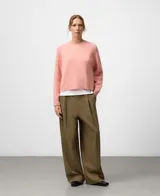 Sweater de punto color rosa, de corte corto con cuello redondo y mangas largas. Presenta acabados en canalé en cuello, puños y bajo. Confeccionado en una mezcla de lana merino y alpaca que ofrece una textura suave y abrigada.