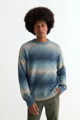 Sweater de tejido de punto con diseño degradé en tonos azules y beige, de corte holgado, cuello redondo y mangas largas.
