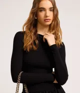 Vestido corto negro con parte superior ajustada de rib y falda globo de tricolina acanalada. Tiene cuello redondo y mangas largas.