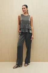 Pantalón negro de corte recto y tela liviana con brillo metalizado.