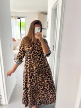 Vestido camisero largo con estampado animal print de leopardo, cuello camisero, cierre frontal con botones y mangas tres cuartos con puños vueltos.