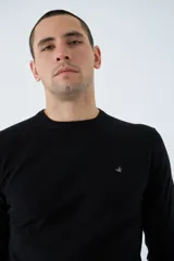 Sweater de tejido de punto con mezcla de algodón y cashmere, de calce regular, con escote redondo a la base, mangas largas y puños y dobladillo acanalados. Presenta un pequeño logo bordado en el pecho.