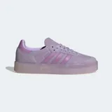 Championes Adidas modelo Sambae, una actualización del clásico Samba con una suela elevada y exterior de cuero nobuk. Presentan las 3 rayas dentadas y puntera en T reforzada. Color violeta claro con suela translúcida.