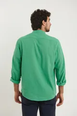 Camisa de cuello mao y manga larga, confeccionada en una mezcla de lino y algodón. Presenta un diseño de corte recto con botones en tono natural y un bolsillo pequeño en el pecho.