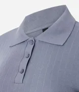 Blusa de punto acanalado color azul, con cuello polo, cierre frontal de botones y mangas cortas con terminación tipo frufru.