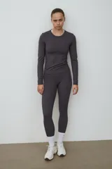 Remera deportiva gris de manga larga, con cuello redondo y corte ajustado, confeccionada en tejido funcional con tecnología DryMove.