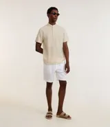 Camisa de manga corta confeccionada en mezcla de lino y algodón, con cuello tipo padre y cierre frontal parcial con botones.