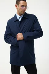 Gabardina azul marino con cuello clásico, cierre frontal con botones y bolsillos laterales.