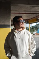Hoodie canguro blanco de diseño oversize, con capucha, bolsillo frontal tipo koozban y sutil bordado monocromático en el pecho.
