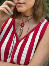 Collar con dije de cuerno de guampa y corales naturales engarzado en alpaca. Tiene tiento sintético color camel con cierre deslizable para regular el largo y usarlo doble.