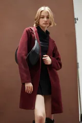 Cartera tipo hobo de diseño curvo, color negro, con correa de cadena dorada y cierre superior.