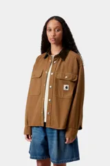 Chaqueta de lona de algodón marrón de peso medio, con cuello de pana y dos bolsillos en el pecho con botones. Incluye cierre frontal con botones a presión y etiqueta con el logo de la marca en el bolsillo izquierdo.