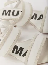 Sandalias de tacón bajo y redondo, con diseño de tiras finas en gamuza y paneles laterales de material translúcido. Cuentan con cierre de pulsera ajustable al tobillo.