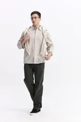 Camisa de popelina a cuadros, color celeste y blanco, de manga larga y corte holgado. Presenta un bolsillo frontal y cartera abotonada.