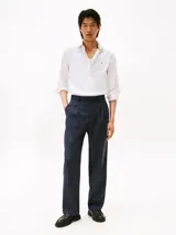 Camisa blanca de popelina de algodón regenerativo, corte slim fit, manga larga, cuello abotonado, cierre con botones y logo de Tommy Hilfiger bordado en el pecho.