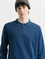 Remera de punto canalé francés con cuello polo, manga larga y cierre frontal de metal con tirador personalizado.