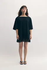 Remerón gris de cuello bote, con bordado del monograma de la marca a tono y encaje blanco integrado en el ruedo. Confeccionado en malla fina compactada de algodón.