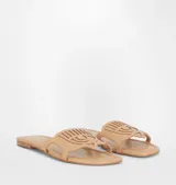 Sandalias planas color beige con detalle de logo de ojo en la tira superior.