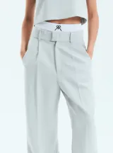 Pantalón de vestir estilo sastrero en color gris, confeccionado en crepe. Presenta un corte recto y holgado con tajo en la botamanga interna y bolsillos laterales.