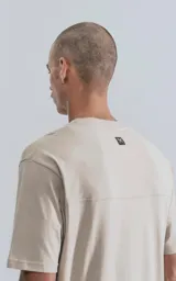 Remera de manga corta y cuello redondo, color beige claro, con calce regular y recorte en la espalda.