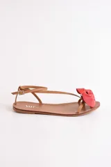 Sandalias bajas color cuero con tiras finas y aplique de flor dorada.