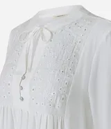 Blusa tipo bata de color celeste con mangas largas y cuello mao con lazo. Presenta detalles de bordado floral calado tipo laise en el frente y cierre parcial con botones.