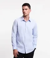 Camisa de vestir blanca de algodón con textura maquinetada, cuello camisero y mangas largas.