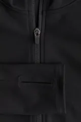 Campera deportiva de corte ajustado confeccionada en tejido funcional con tecnología SoftMove y DryMove. Presenta capucha, cierre frontal con protección para el mentón, bolsillos laterales con cierre y mangas extralargas con abertura para el pulgar.