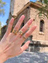 Anillo dorado con diseño de racimo de pequeñas esferas.