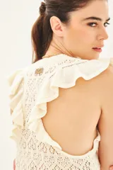 Musculosa de punto calado color crudo, con volados en las sisas y cuello redondo.