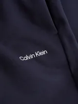 Pantalón de jogging azul marino de algodón y poliéster reciclado, con cintura elástica, bolsillos laterales y logo de Calvin Klein en la pierna izquierda.