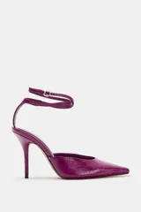 Zapato de tacón destalonado color fucsia con efecto charol, punta fina, tacón fino alto y tiras finas ajustables alrededor del tobillo con hebilla metálica.