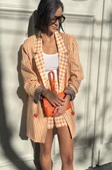 Short sastrero de lino con estampado de rayas verticales naranjas y blancas, corte holgado.