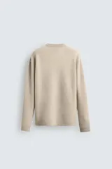 Jersey de punto canalé con cuello redondo y manga larga, confeccionado en hilatura de cashmere. Presenta un corte regular fit con acabados en rib en puños y bajo.