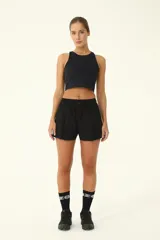 Short deportivo negro con diseño de falda con tablas encontradas en el frente y bolsillos laterales.